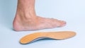 The left leg of an adult male with signs of foot disease next to the orthopedic insole. Means for the treatment of flat Royalty Free Stock Photo