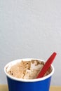 Left over chocolate ice cream in blue paper cup and red spoon with copyspace. Selective focus Royalty Free Stock Photo