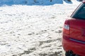 Left rear of red car on snowy surface