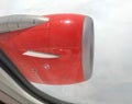 A left-side red airplane engine was working on the sky. Royalty Free Stock Photo