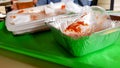 Leftover food, dirty plastic dishes on a green tray on a table in an outdoor cafe