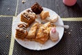 Leftovers in a plate on the table with sweets cakes, close-up