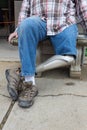 Leg amputee sitting on bench with hands by sides, legs crossed Royalty Free Stock Photo