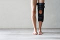 Leg brace on knee against gray wall background, knee brace support for leg or knee injury Royalty Free Stock Photo