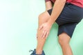 Leg cramps pain and injury concept. Young asian athlete man in running clothes holding his calf muscle