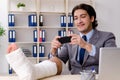 The leg injured employee working in the office Royalty Free Stock Photo