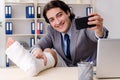 The leg injured employee working in the office Royalty Free Stock Photo