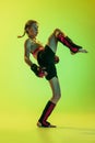 Dynamic portrait of athletic girl, MMA fighter training isolated on gradient yellow-green background in neon. Concept of