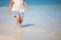 Leg of little child girl running on beach with water splashing in vacation Royalty Free Stock Photo