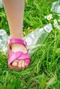 Leg of a little girl tramples a plastic bottle