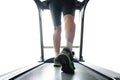 Leg of man running on treadmill in the gym which runner athletic by running shoes. on white background Health and sport