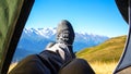 leg tourist in boots out of the tent with mountains in the background Royalty Free Stock Photo