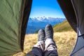 leg tourist in boots out of the tent with mountains in the background Royalty Free Stock Photo