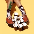 Leg in vintage striped socks and shoes in stylish isometric sweet cups space. Minimal still life food art. Chocolate lover.