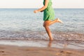 Leg of woman running on beach with water splashing. summer vacation. legs of a girl walking in water on sunset Royalty Free Stock Photo