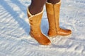 Leg woman winter brown fur boots walking on the snow in a winter park. Closeup outsole of warm boot. Royalty Free Stock Photo