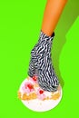 Leg in zebra Party Boots crush yummy cake. Minimal fashion food art Royalty Free Stock Photo