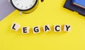 LEGACY word made with building blocks, yellow background,money or property left to someone legacy concept