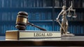 Legal AID: Judge's Gavel as a symbol of legal system , Themis is the goddess of justice and wooden stand with text Royalty Free Stock Photo