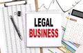 LEGAL BUSINESS text on notebook with chart, calculator and pen Royalty Free Stock Photo