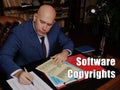 Legal concept about Software Copyrights Male office workers with yellow shirt holding and writing documents on office desk