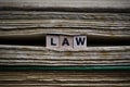 Legal conditions framework concept: Closeup of isolated antique old book pile text blocks and yellowed pages with wooden alphabet Royalty Free Stock Photo