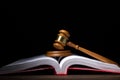 Legal law and justice concept. Judges gavel with soundboard on big opened law book against black background Royalty Free Stock Photo