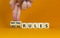 Legal or moral rules symbol. Businessman turns wooden cubes and changes words `legal rules` to `moral rules` on a beautiful or
