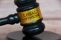 Legal opinion text engraved on lawyer gavel with blurred wooden background. Legal and law concept