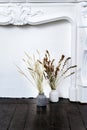 Legant home interior in white tones under fireplace decorated.