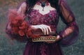 Legend of Pandora`s box, girl with black hair, dressed in a purple luxurious gorgeous dress, an antique casket opened