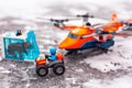 Lego all-terrain vehicle with explorer, saber-toothed tiger in ice and heavy-duty quadrocopter with 4 spinning rotors on ice Royalty Free Stock Photo