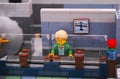 Lego bank manager on his working place with security glass