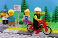 Lego boy riding bicycle waving to his friends