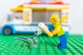 Lego brand male figurine sharing ice cream with a small velociraptor figurine