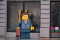 Lego businessman standing on the street in front of a bank