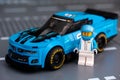 Lego Chevrolet Camaro ZL1 race car with driver minifigure by LEGO Speed Champions standing on road beseplates