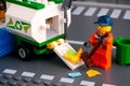 Lego cleaner with brush cleaning street and putting garbage in street sweeper truck Royalty Free Stock Photo