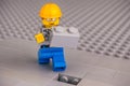 Lego construction worker with gray brick ready to finishing building wall Royalty Free Stock Photo