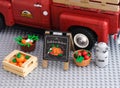 Lego crates of vegetables, milk bucket and sign Fresh from the Farm on a gray baseplate background near Lego pickup truck