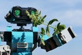 LEGO Creator robot examining closely fresh tip of Mint plant, possibly Mentha Spicata