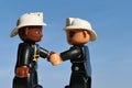 LEGO Duplo firefighers of african american and caucassian race shaking their hands with wide smile Royalty Free Stock Photo