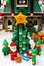 Lego Elves, Reindeer and Santa Claus with bag standing near Christmas tree opposite Elf Club House