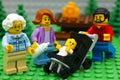Lego family - father, mother, grandmother and baby in stroller in park