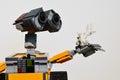 LEGO figure of Wall-E robot from Disney Pixar movie adoring white sea coral in his left arm, light grey background.