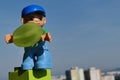 LEGO figure of young boy with blue baseball cap holding fresh grape fruit.