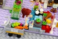 Lego girl with trolley in supermarket weighing vegetables