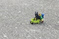 Lego hiker pushing wheel barrow with batman sit on it.