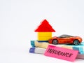 A lego house and toy car on money notes with INSURANCE word, shot against white background Royalty Free Stock Photo