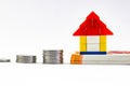 A lego house toy with coins and money notes shot against white background Royalty Free Stock Photo